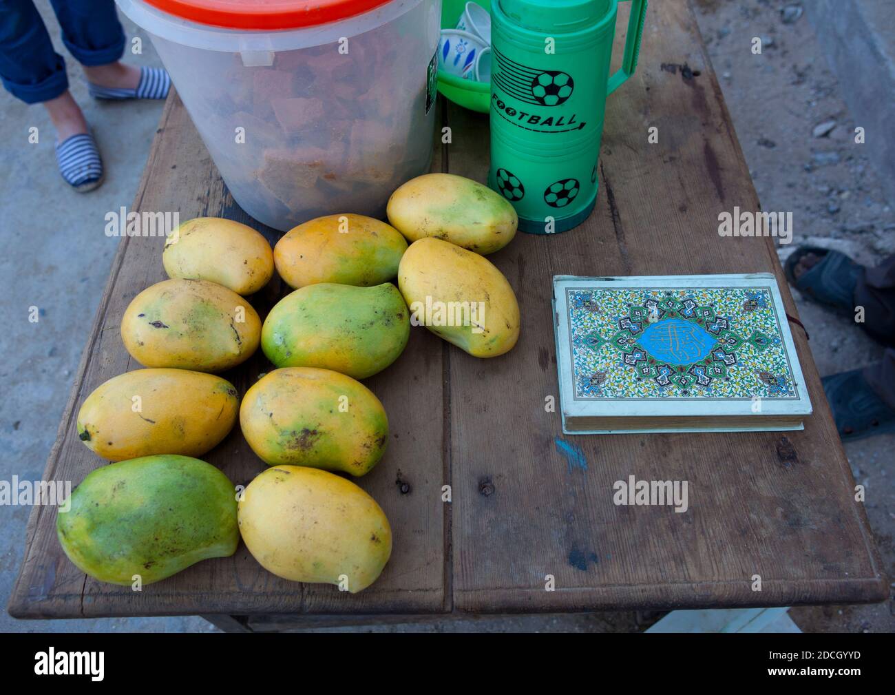 Mango fruit stall vendeur de rue avec un livre kuran, Lamu County, Lamu, Kenya Banque D'Images