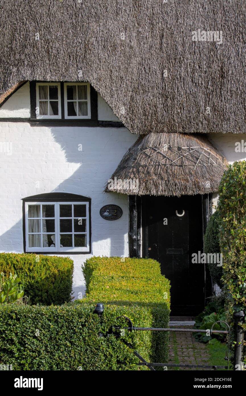 Façade d'UN cottage en chaume avec fenêtres et porte avant noire et porche en chaume anglais 18ème siècle Cottage en chaume, classé Grade 2. Vert cygne Cot Banque D'Images
