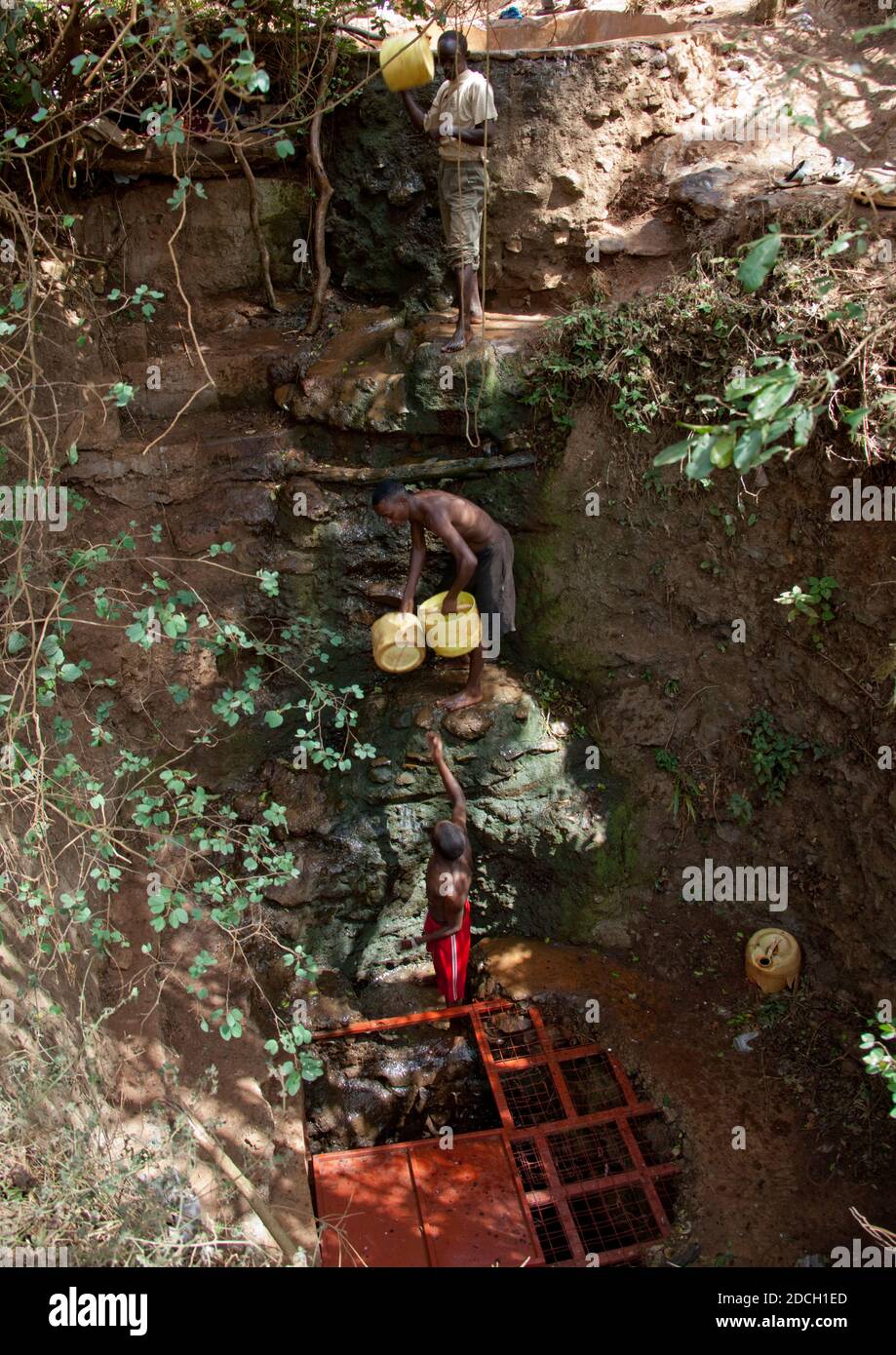 Des hommes collectant de l'eau dans un puits de chant Borana, comté de Marsabit, Marsabit, Kenya Banque D'Images