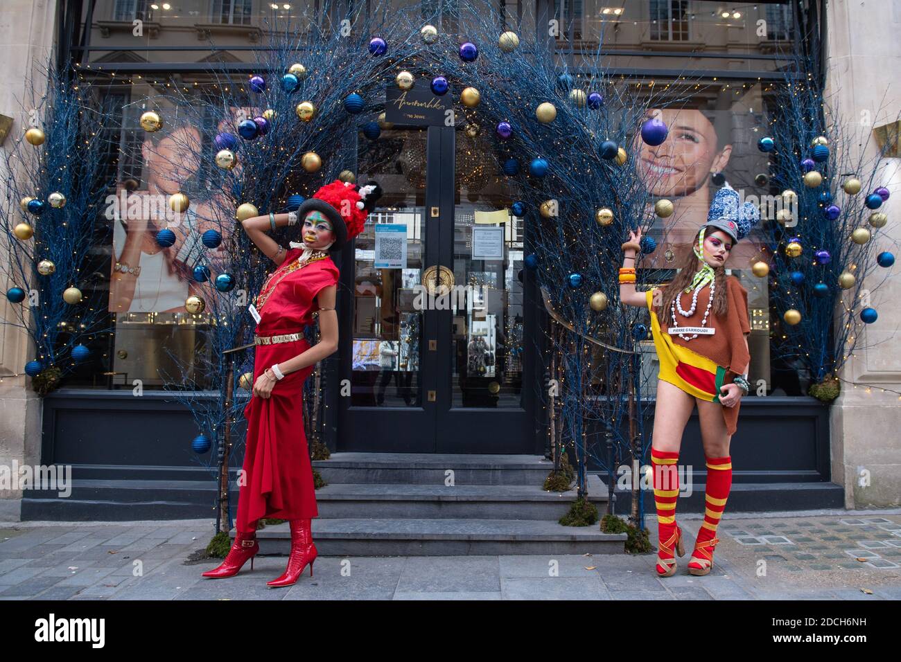 Les modèles se démarquent parmi les décorations de Noël tandis qu'ils présentent des vêtements du designer de mode Pierre Garroudi, lors d'une séance photo de mode flashmob sur Oxford Street, Londres. Banque D'Images