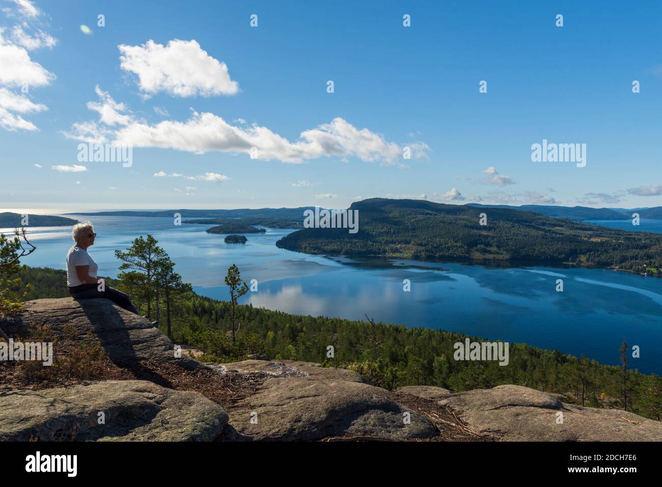 Les femmes âgées sont assises sur une falaise en regardant vers le Sud D'une montagne (Getsvedjberget) dans la région de la haute côte à Vasternorrland Suède avec îles alon Banque D'Images