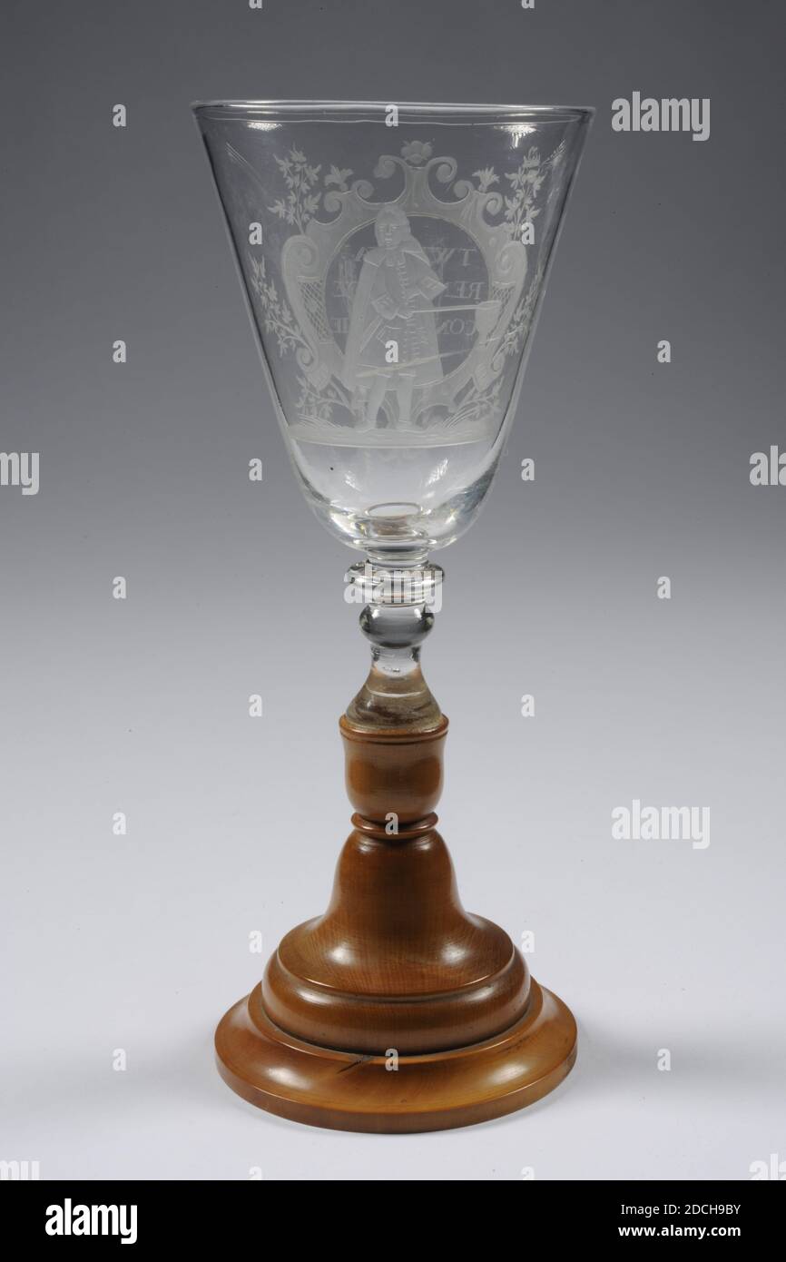 Chalice, troisième quart du XVIIIe siècle, bois de palmier, verre, général: 22 x 8,7 cm 220 x 87 mm, mâle, Chalice de verre incolore sur une base en bois. La base ajoutée en 1980 avec la restauration est faite de bois de palme. Puis suit le tronc court, massif, mince avec 2 boutons et un collier avec un calice au-dessus. Sur le mur de la calice une image d'un aîné qui se rassemble debout sur une surface herbeuse. Dans sa main droite un sac de collecte sur un bâton et sa main gauche dans sa veste à la hauteur de poitrine. De l'autre côté se trouve une cartouche avec des branches feuillues qui se lit comme suit: 'T WELVA: REN VAN de CONSISTORIE, en trois lignes. Activé Banque D'Images