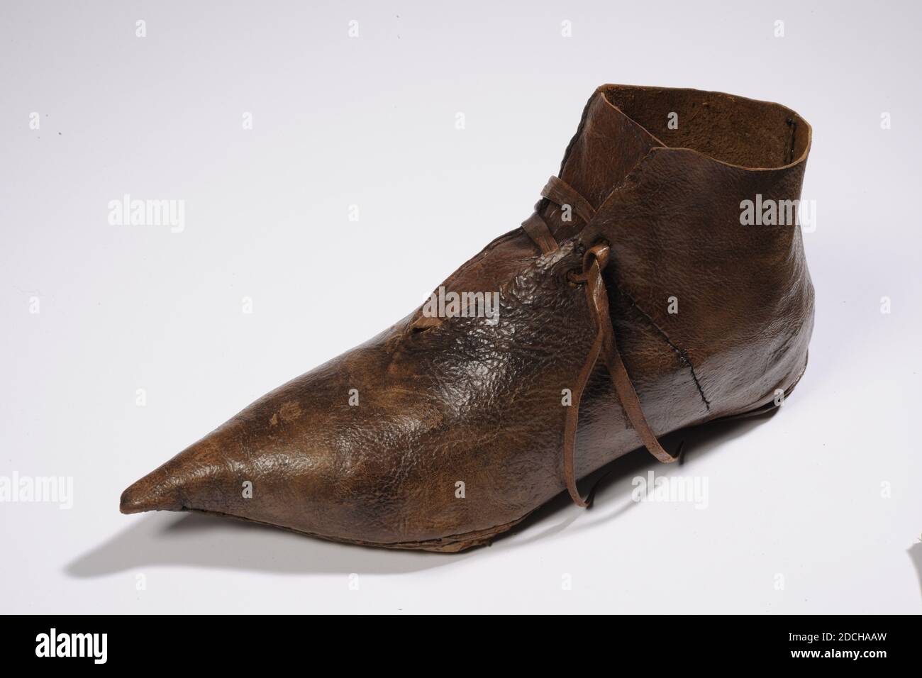 chaussure de toot, Anonyme, XIVe siècle, cousue, général: 11.8 x 7.8 x 25cm 118 x 78 x 250mm, chaussure de Toot en cuir, également appelée Beak Shoe, en raison de la pointe pointue. Il s'agit d'une chaussure montante qui s'élève au-dessus de la cheville. La chaussure est entièrement en cuir, y compris les lacets. Il y a un trou dans la semelle. Le patin est rembourré de foin et d'un tissu tricoté marron, 1995 Banque D'Images