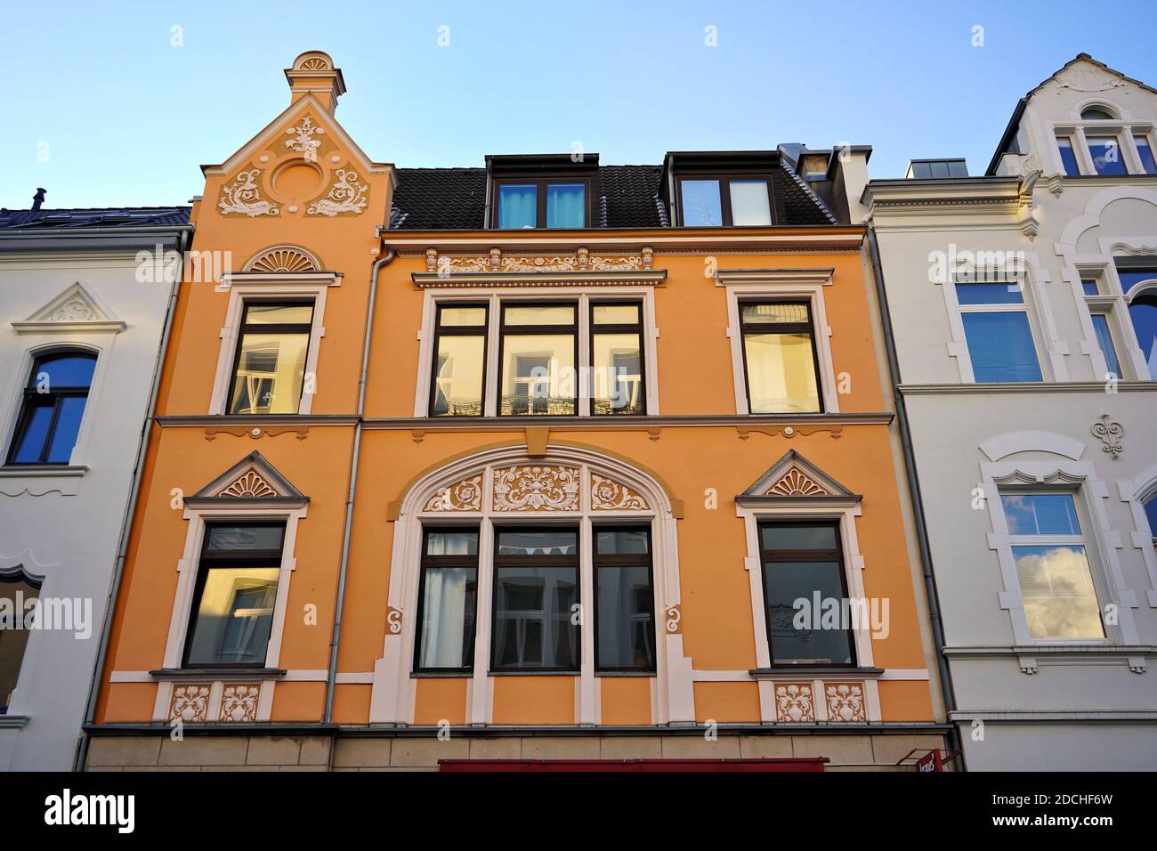 Façade d'une maison orange colorée à Düsseldorf, quartier d'Oberkassel, au soleil de la fin de l'après-midi. Banque D'Images