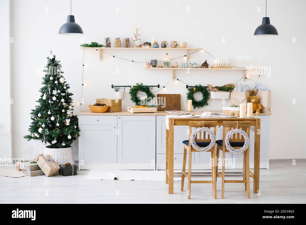 Nouvel an et Noël. Cuisine scandinave festive dans des décorations de Noël. Bougies, branches de sapin, supports en bois, table. Banque D'Images