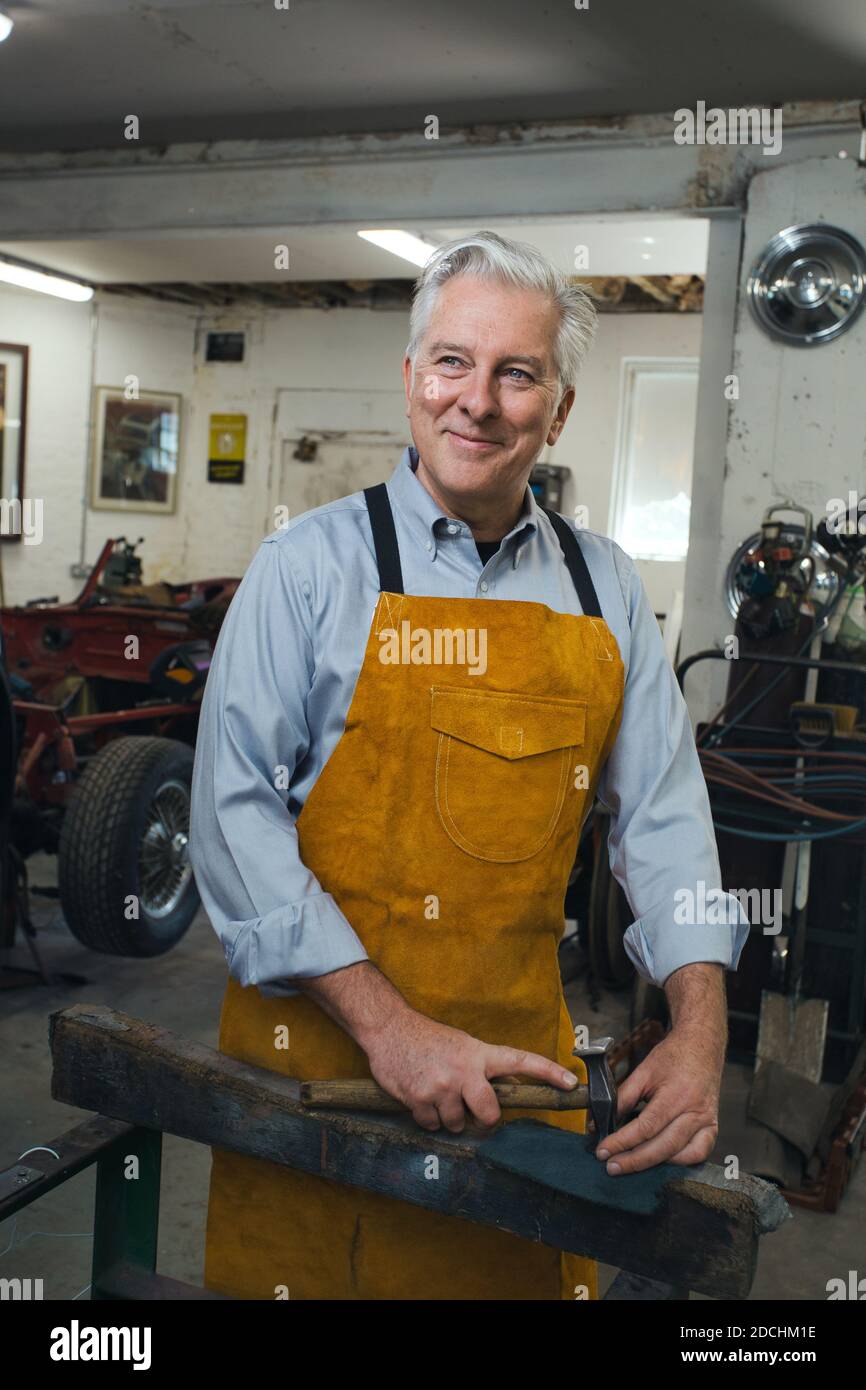 Homme travaillant sur la voiture dans un atelier de garage. Banque D'Images