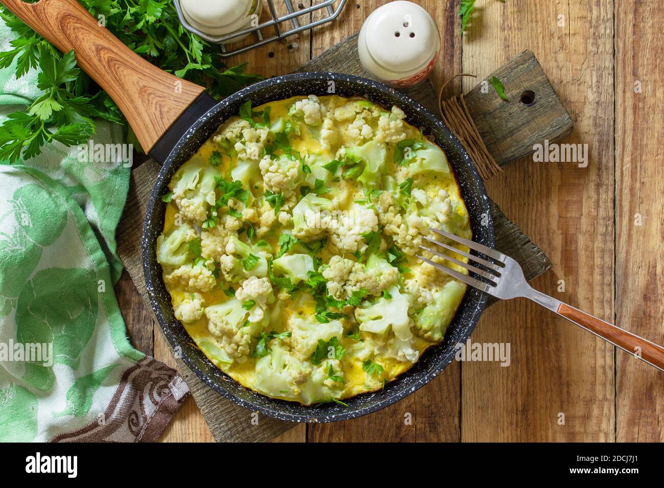 Un petit déjeuner diététique ou un déjeuner sain. Omelette aux oeufs avec chou-fleur dans une poêle en fonte sur une table rustique en bois. Vue de dessus de l'arrière-plan de la mise à plat Copier l'espace. Banque D'Images
