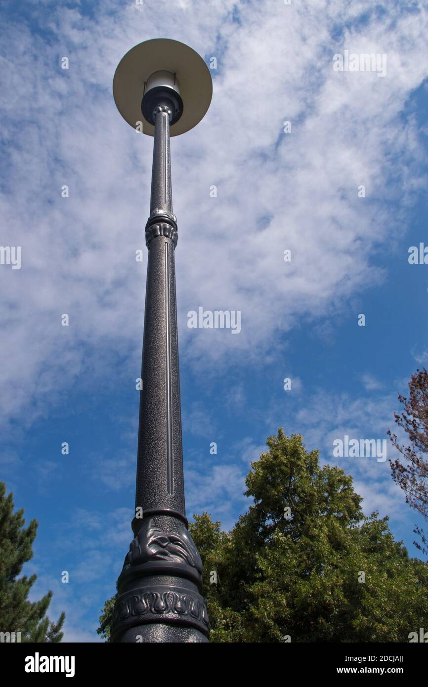 Abat-jour de parasol blanc rond d'une lampe de rue sur un poteau haut métal  noir décoré avec bas relief contre le ciel bleu et le bouc souillé f Photo  Stock - Alamy