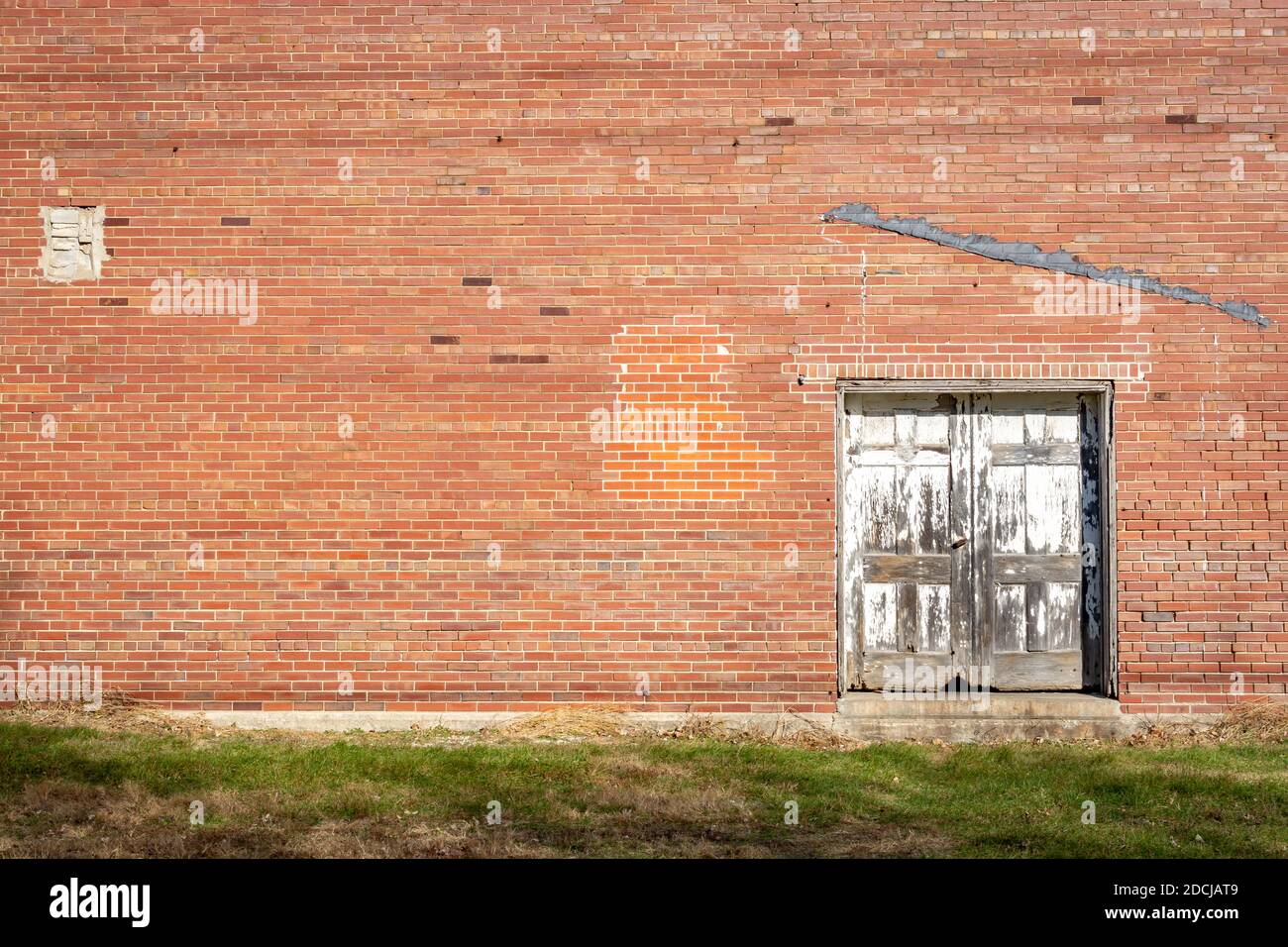 Arrière-plan en briques grungy et porte en bois pourrie. Amboy, Illinois. Banque D'Images