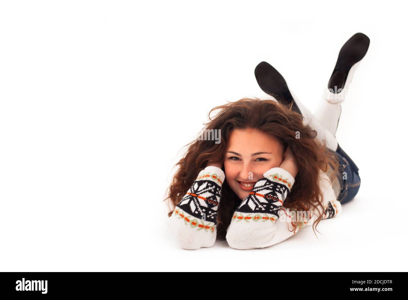 Jeune fille avec cheveux de curly dans un chandail et blanc Boots se moque sur un fond blanc isolé Banque D'Images