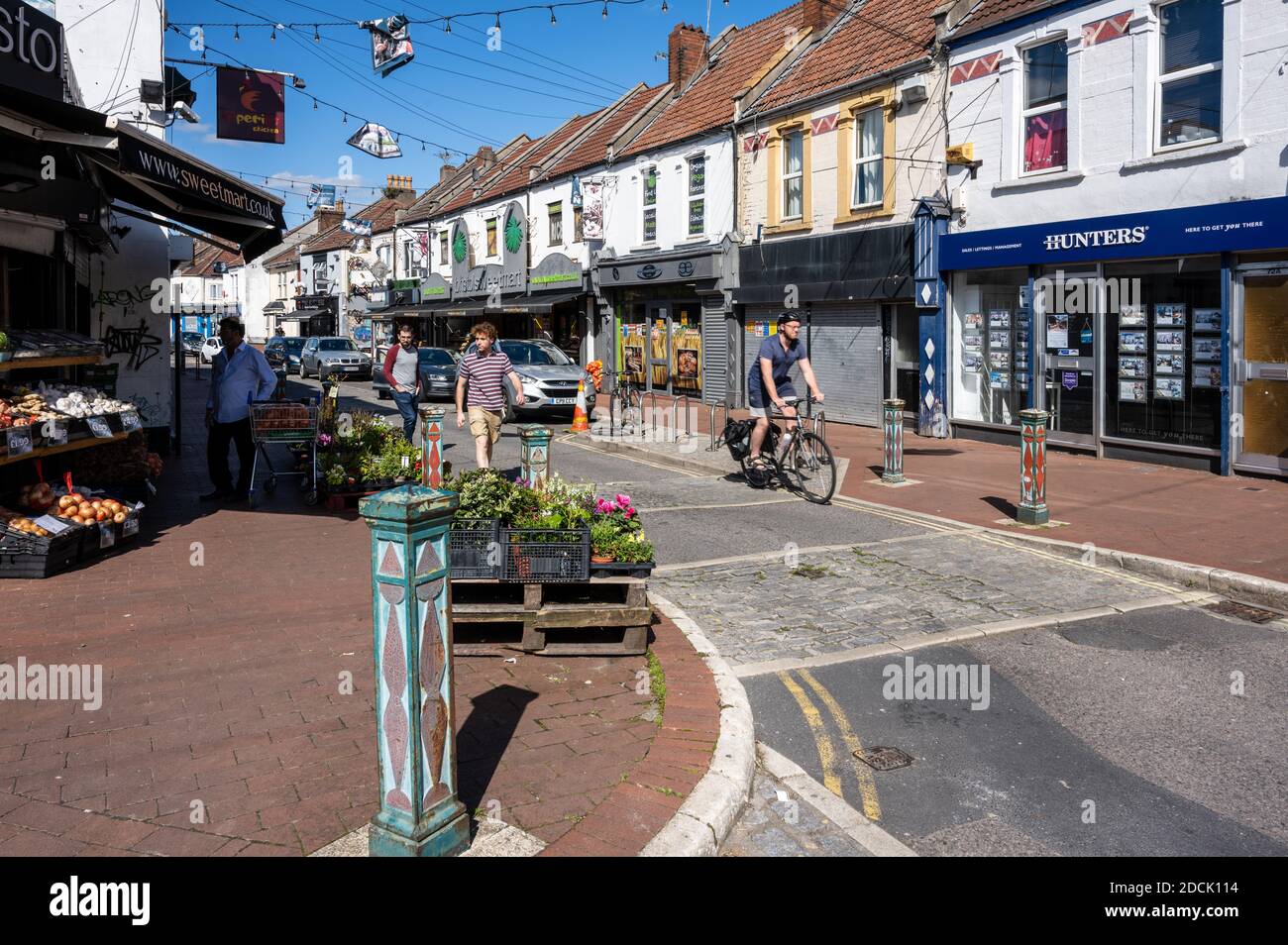 Les amateurs de shopping se prominent à pied et à vélo devant les boutiques indépendantes de la célèbre rue commerçante St Mark's Road à Easton, Bristol. Banque D'Images
