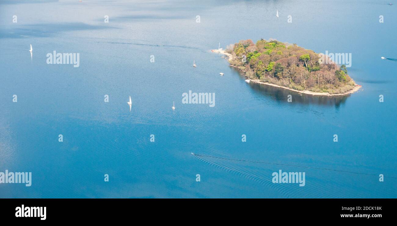 Des bateaux naviguent autour de la petite île boisée de St Herbert, dans le lac Derwent Water, vue depuis la montagne de Catbells, dans le district des lacs d'Angleterre. Banque D'Images