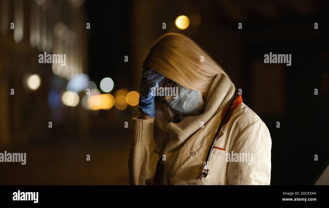 Un jeune étudiant en médecine fait un signe de paume du visage la nuit Banque D'Images