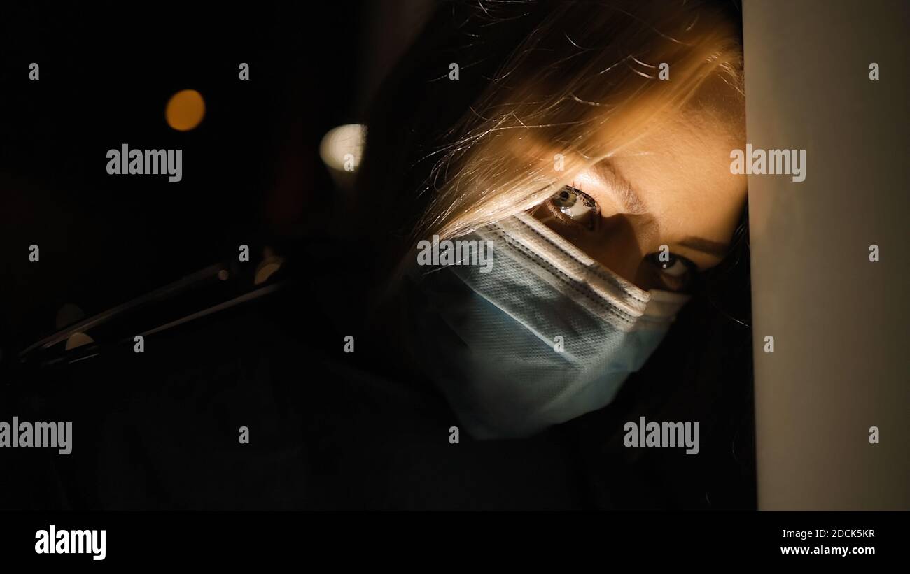 Vue rapprochée : femme médecin fatiguée et effrayante la nuit Banque D'Images