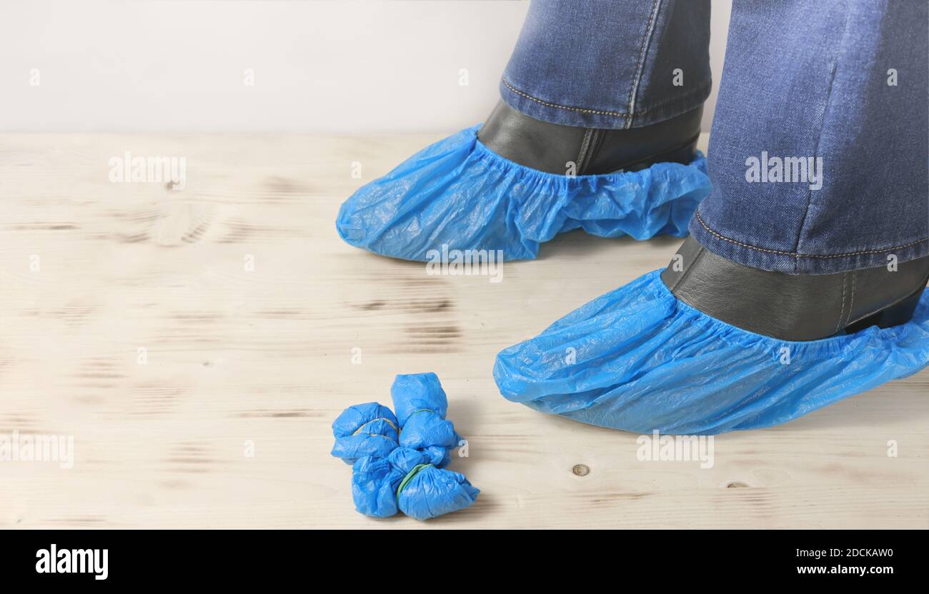 couvre-chaussures bleus jetables pour les visites à l'hôpital sur les  bottes de femme sur parquet. femme portant des couvre-chaussures pour la  protection et la propreté dans le domaine médical Photo Stock -