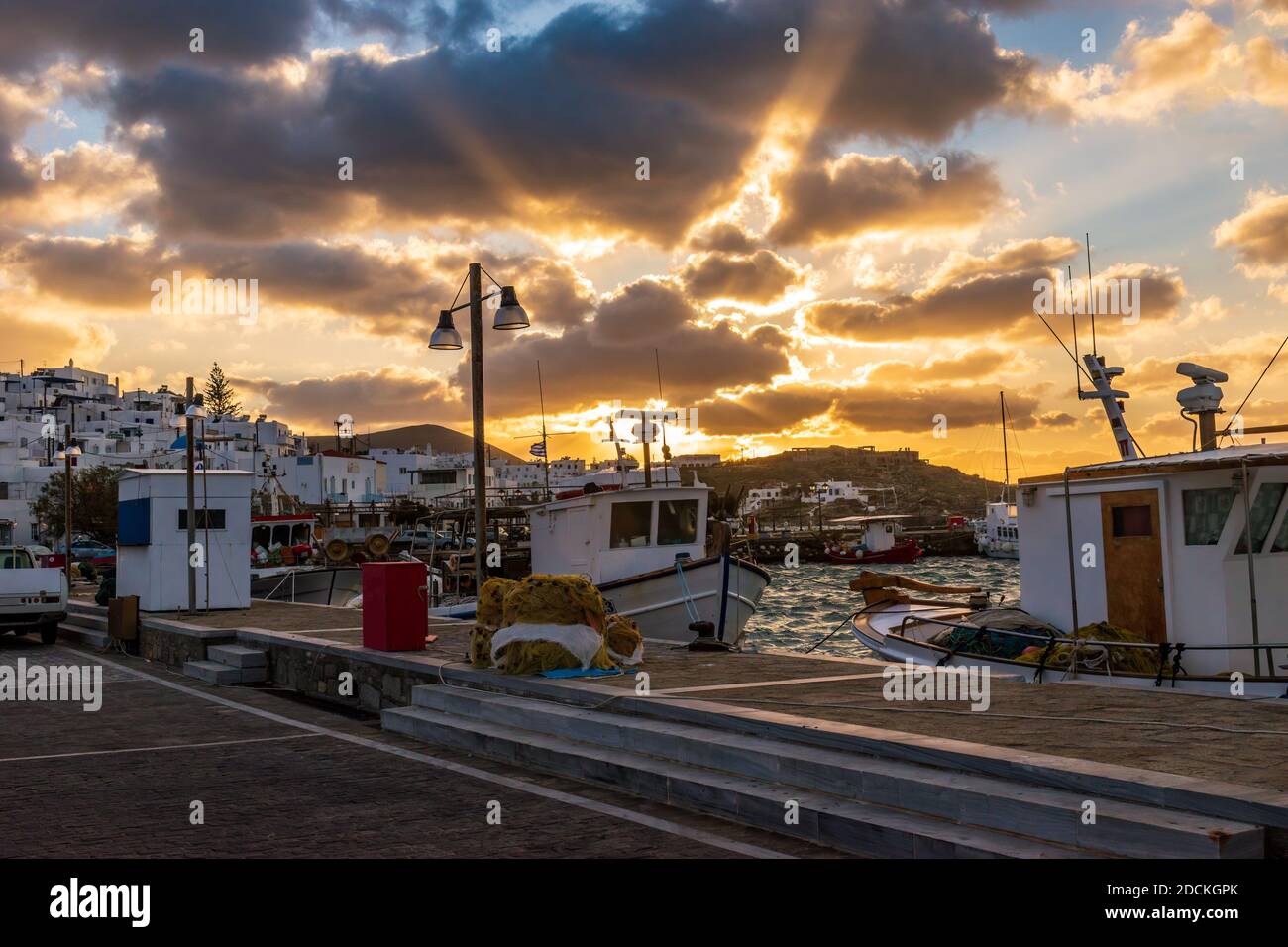 Vue traditionnelle sur les Cyclades avec des bateaux de pêche traditionnels amarrés pendant un coucher de soleil étonnant sur le port pittoresque de Naousa Paros, Grèce. Banque D'Images