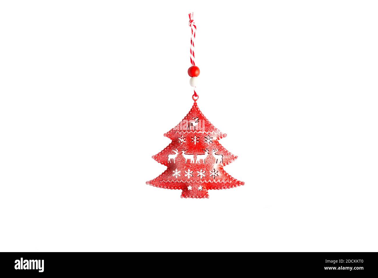 Jouet rouge arbre de Noël en métal avec des fentes sous la forme de cerfs et flocons de neige et une corde rayée sur un fond blanc, isoler. Noël, nouveau y Banque D'Images Jouet rouge arbre de Noël en métal avec des fentes sous la forme de cerfs et flocons de neige et une corde rayée sur un fond blanc, isoler. Noël, nouveau y Banque D'Images