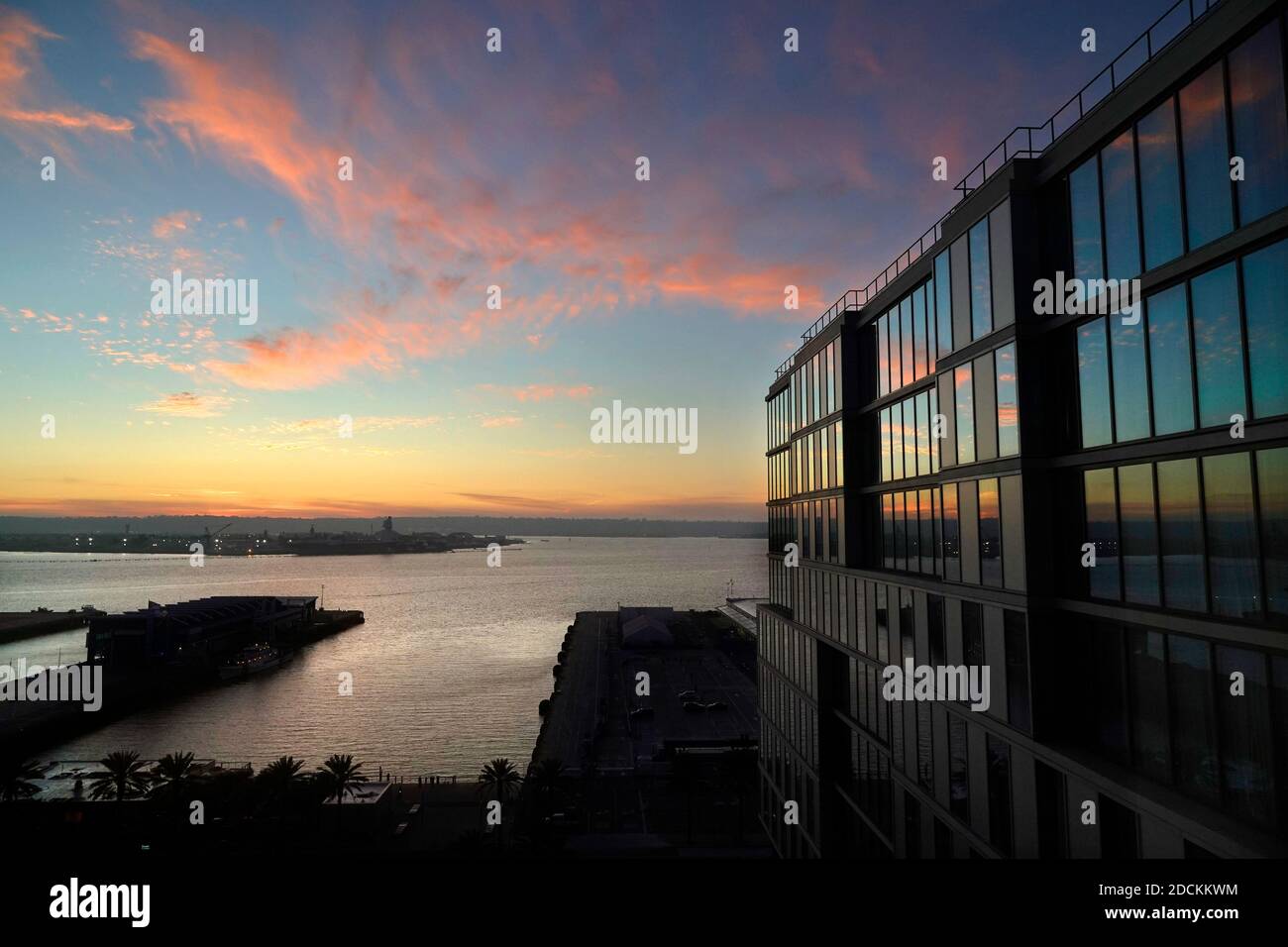 San Diego, Californie, États-Unis. 19 novembre 2020. Le soleil se couche sur la baie de San Diego et se reflète dans les fenêtres d'un hôtel SpringHill Suites by Marriott. Le tourisme, l'une des principales industries de San Diego, a été touché par le ralentissement des voyages dû à Covid-19. Crédit : K.C. Actualités en direct Alfred/ZUMA Wire/Alay Banque D'Images