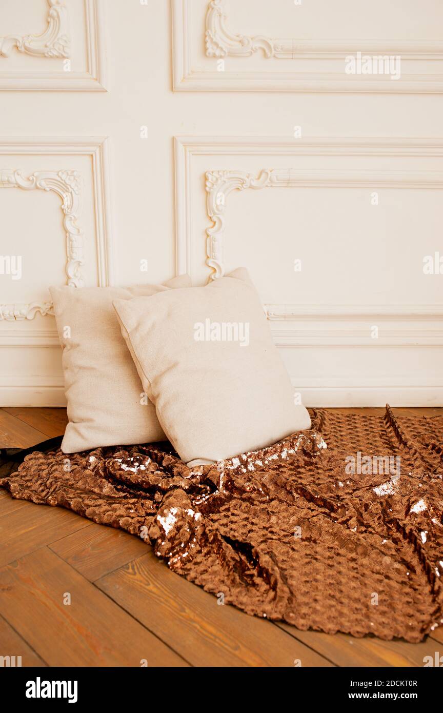 deux oreillers doux et confortables beige sur le parquet avec une couverture en bronze brillant et un stuc blanc sur le mur. minimalisme à l'intérieur, Banque D'Images