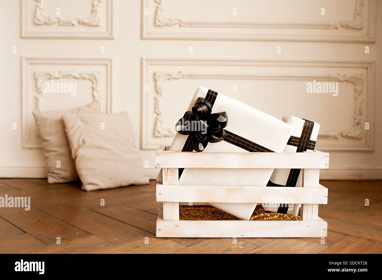 boîtes-cadeaux blanches élégantes avec ruban noir dans une boîte en bois blanc dans un intérieur léger, mise au point sélective Banque D'Images