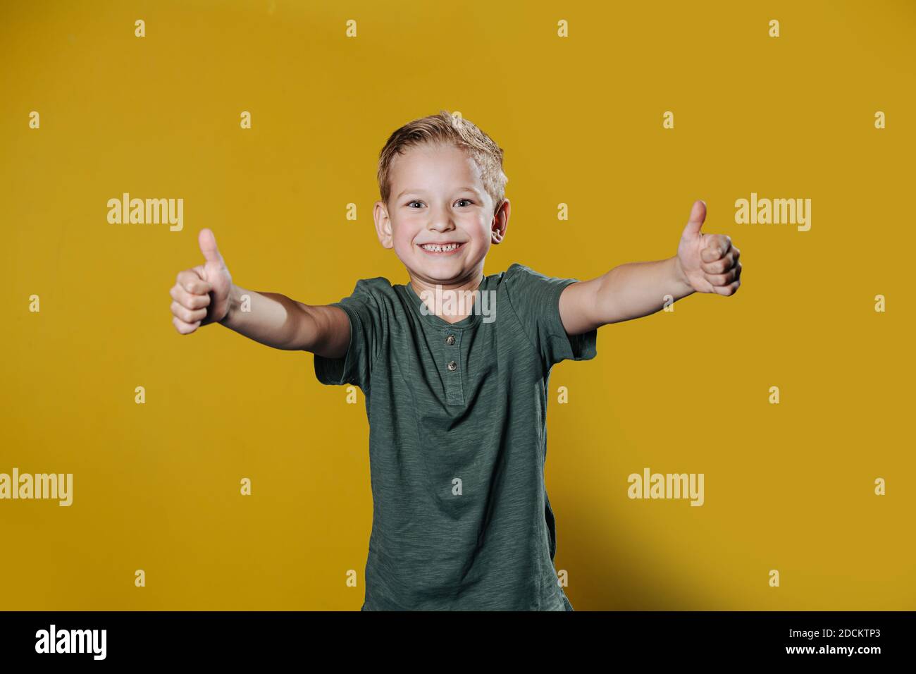 Portrait d'un garçon de dix ans souriant et confiant debout devant le mur Banque D'Images