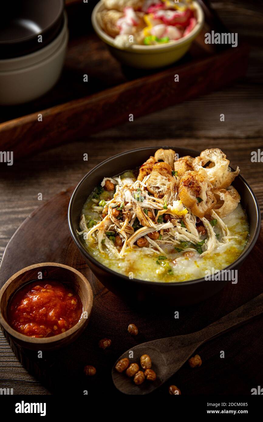 Bubur ayam Bandung ou bouillie de poulet, la nourriture traditionnelle indonésienne se compose de bouillie de riz blanc, poulet râpé, cakwe, soja frit, craquelins Banque D'Images