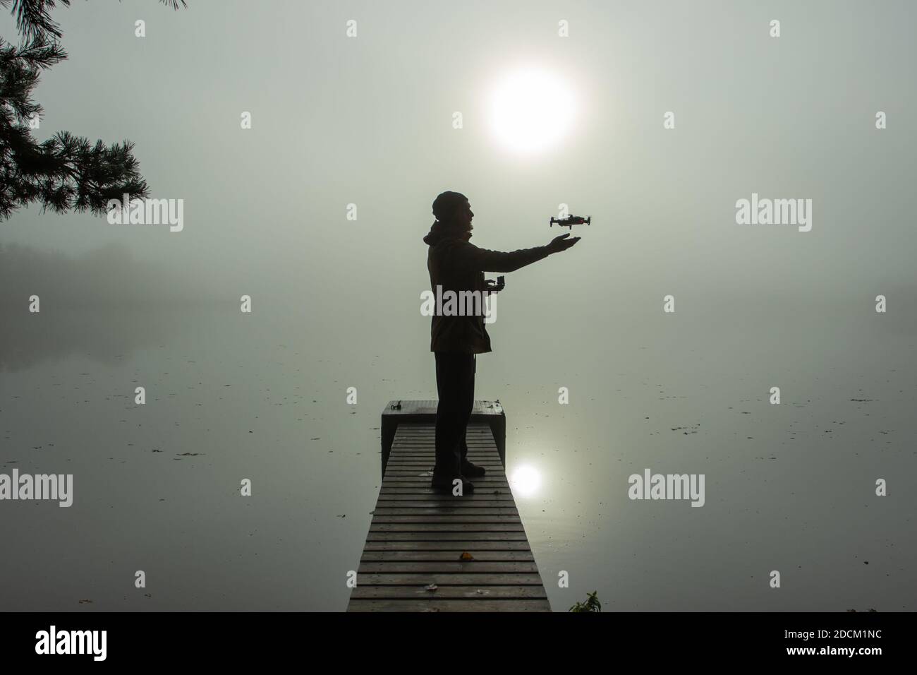 Homme jouant avec le drone. Silhouette contre le paysage brumeux.Homme utilisant le drone par télécommande et s'amuser. Pilote de drone volant. Utilisation Banque D'Images