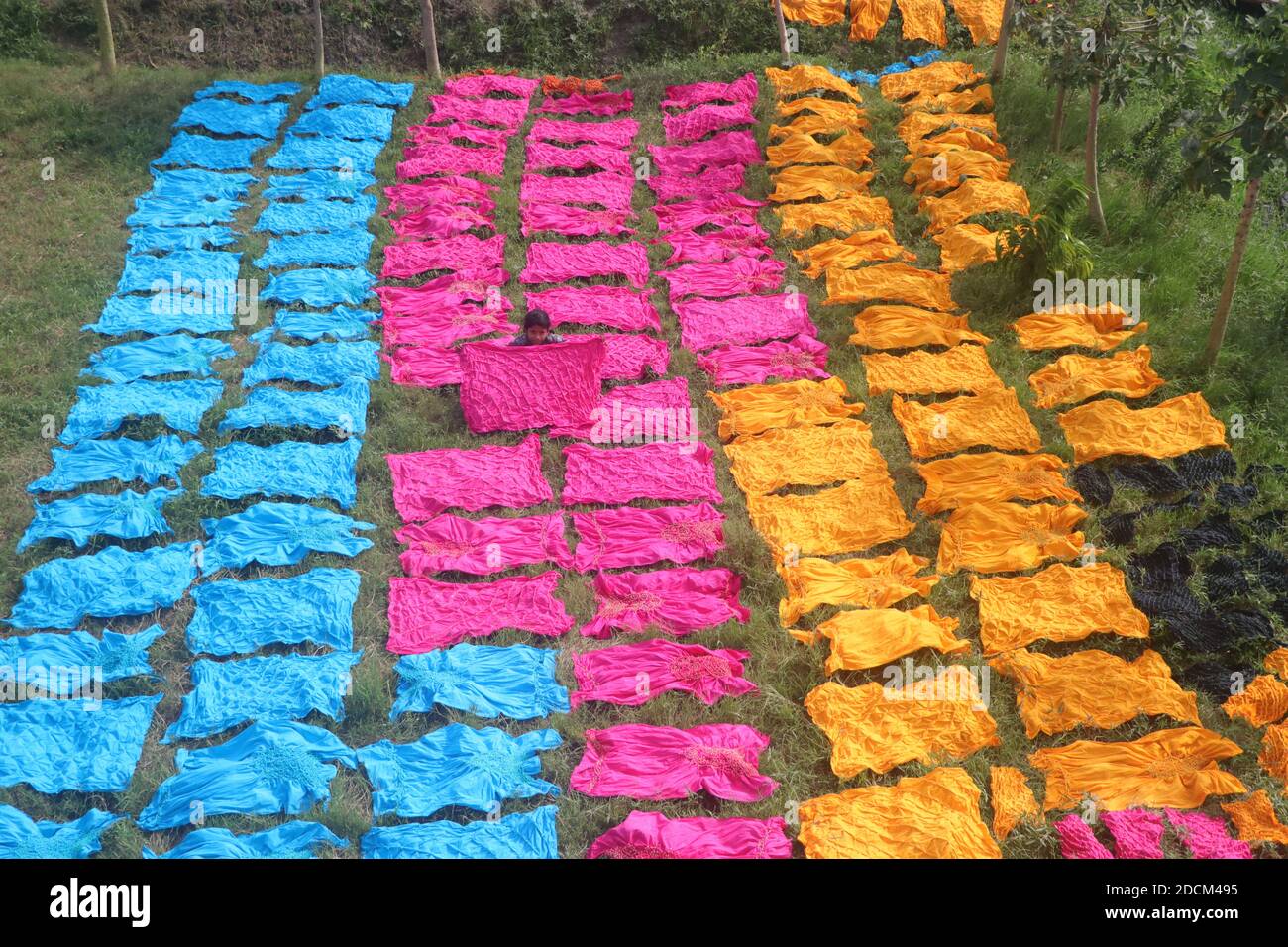 Les travailleurs bangladais collectent des tissus après les avoir séchés sous le soleil dans une usine de teinture à Narayanganj, au Bangladesh. Nazmul Islam/Alamy stock photo Banque D'Images