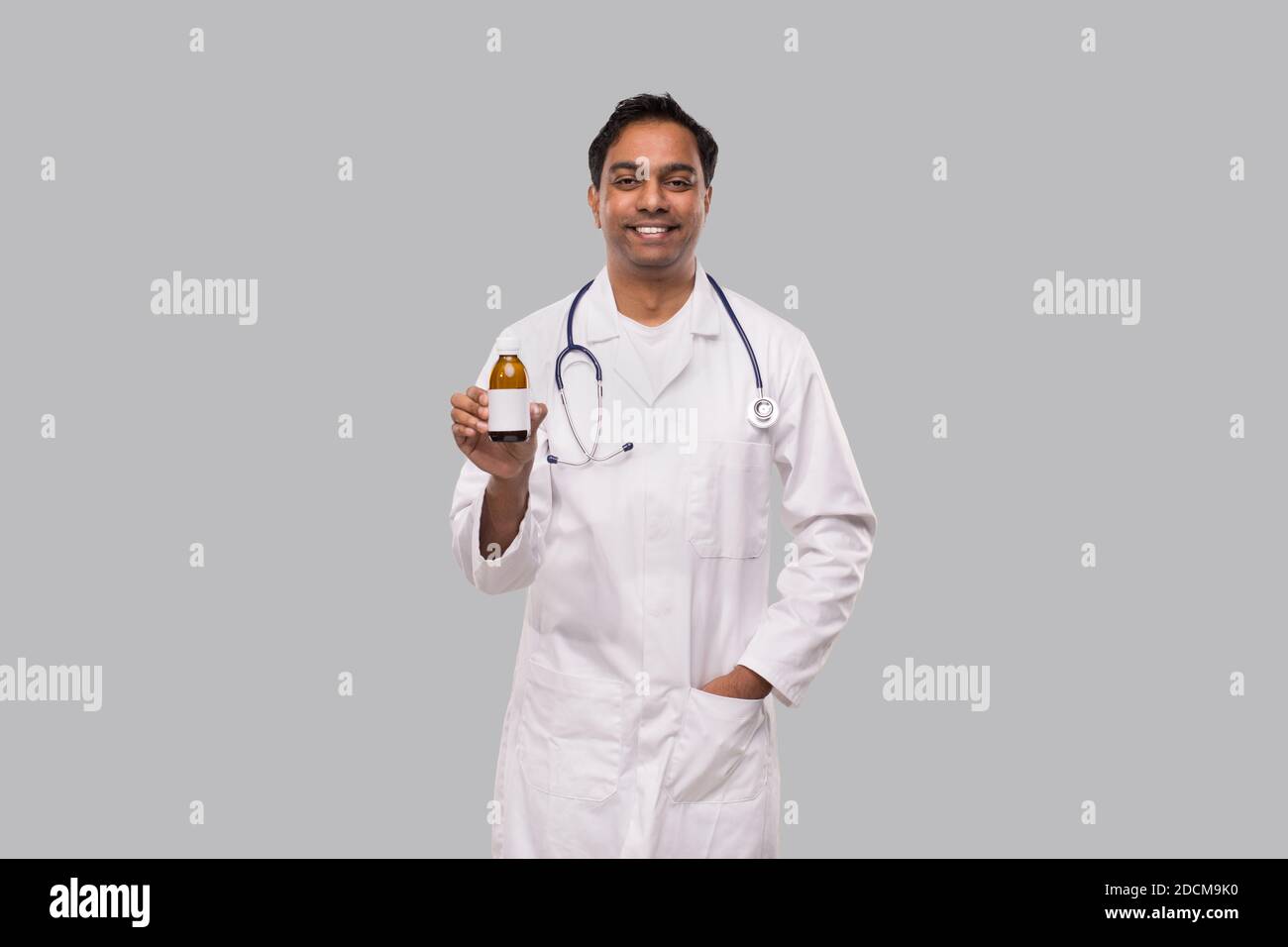 Indian Man Doctor tenant le sirop contre la toux isolé Banque D'Images