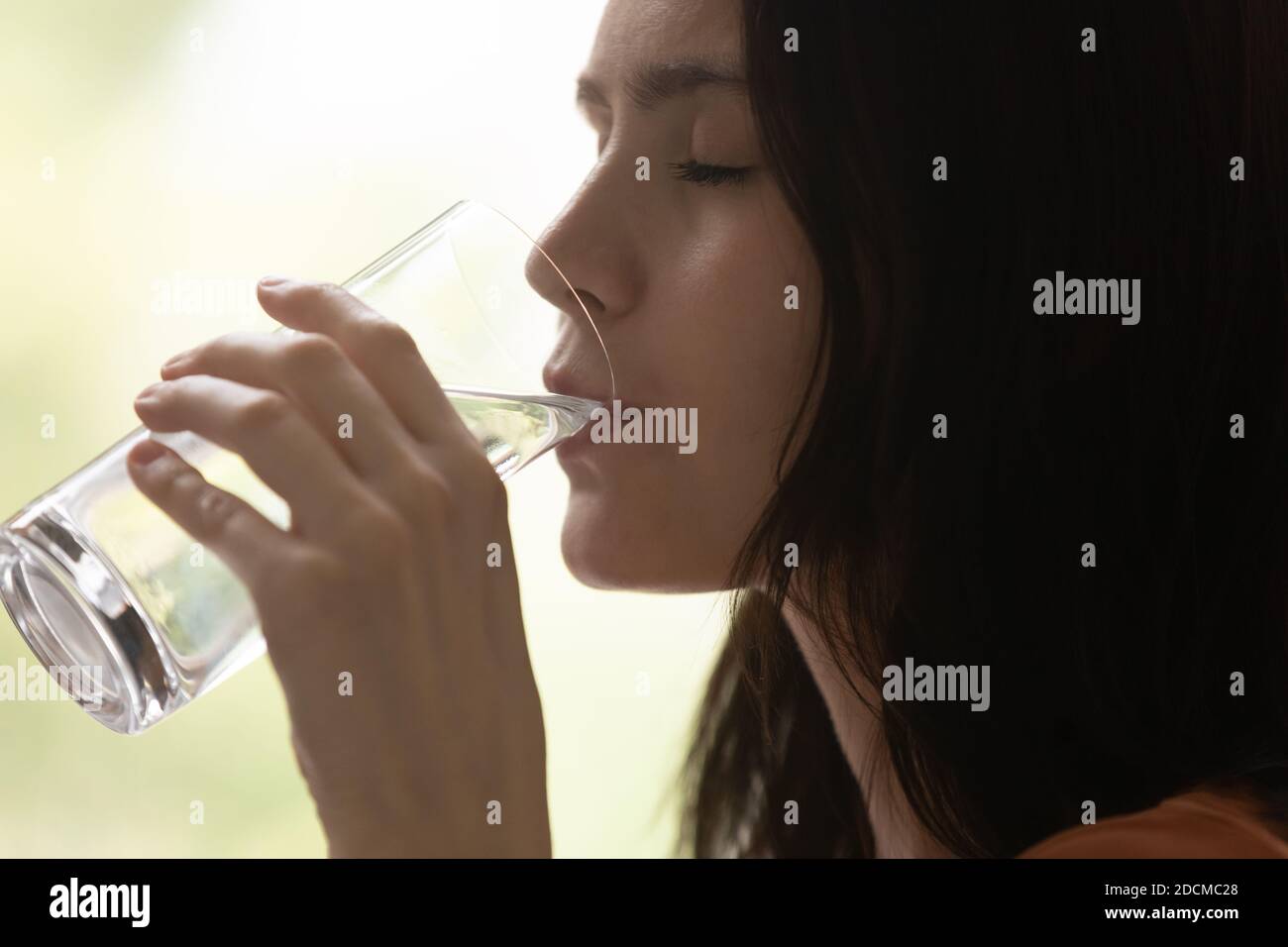 Femme millénaire qui boit de l'eau minérale, qui a soif. Banque D'Images