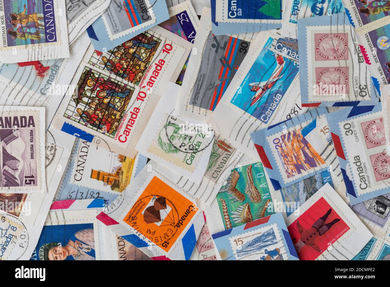 Tas informel de timbres canadiens utilisés des années 1980. Tampons sur papier prêts à être triés et catalogués. Banque D'Images
