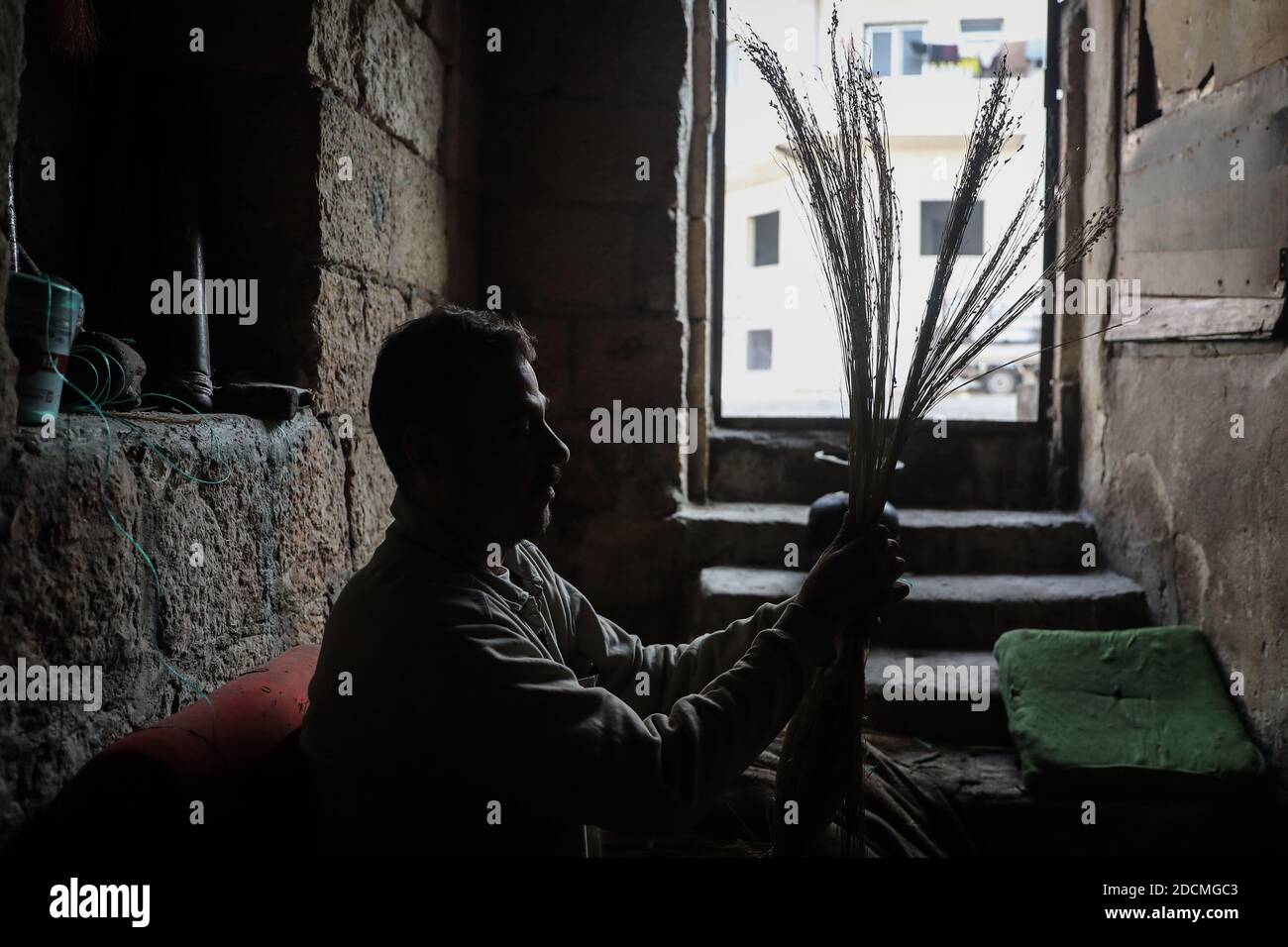 Idlib City, Syrie. 22 novembre 2020. Un ouvrier fabrique des balais de paille faits main dans un petit atelier dans un quartier populaire de la ville d'Idlib. La fabrication de balais de paille a été active au cours des dernières années en raison de la dépendance des résidents au lieu des outils électriques en raison des coupures de courant. Credit: Aras Alkharboutli/dpa/Alamy Live News Banque D'Images