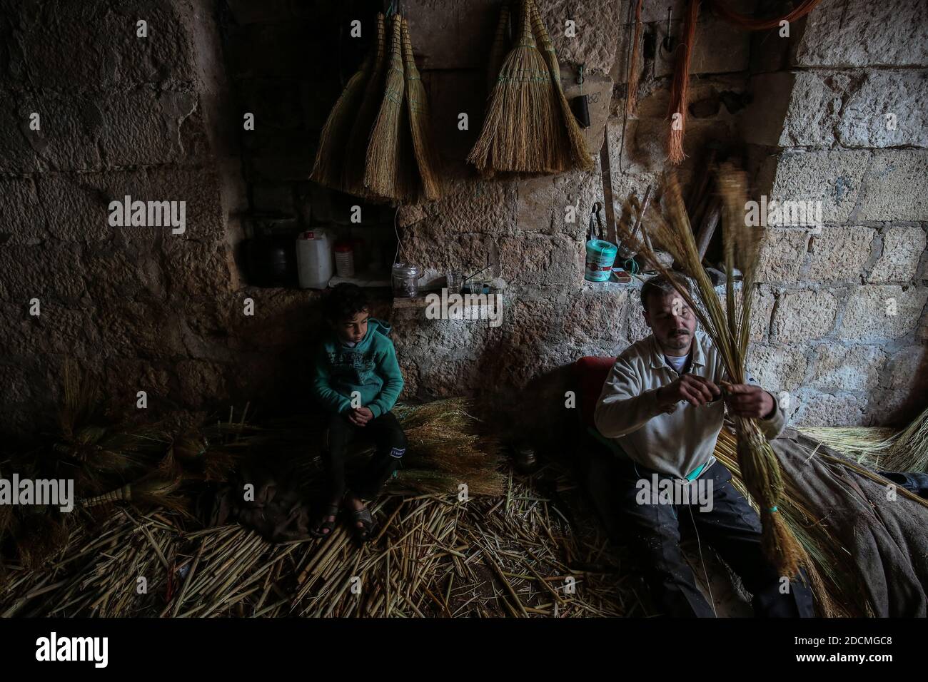 Idlib City, Syrie. 22 novembre 2020. Un ouvrier fabrique des balais de paille faits main dans un petit atelier dans un quartier populaire de la ville d'Idlib. La fabrication de balais de paille a été active au cours des dernières années en raison de la dépendance des résidents au lieu des outils électriques en raison des coupures de courant. Credit: Aras Alkharboutli/dpa/Alamy Live News Banque D'Images
