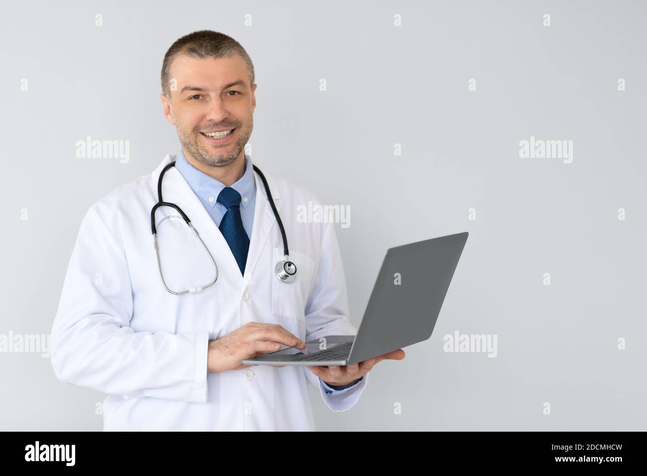 Portrait d'un médecin de sexe masculin tenant un ordinateur portable Banque D'Images