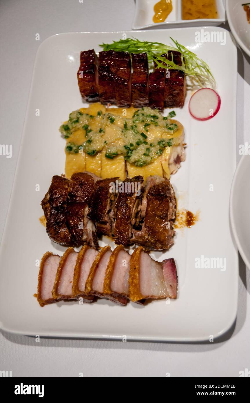 Une sélection de viande grillée de char siu, de porc rôti et de poulet blanc coupé au barbecue est servie au Rongxing Jiujia, un restaurant cantonais de Shanghai Banque D'Images