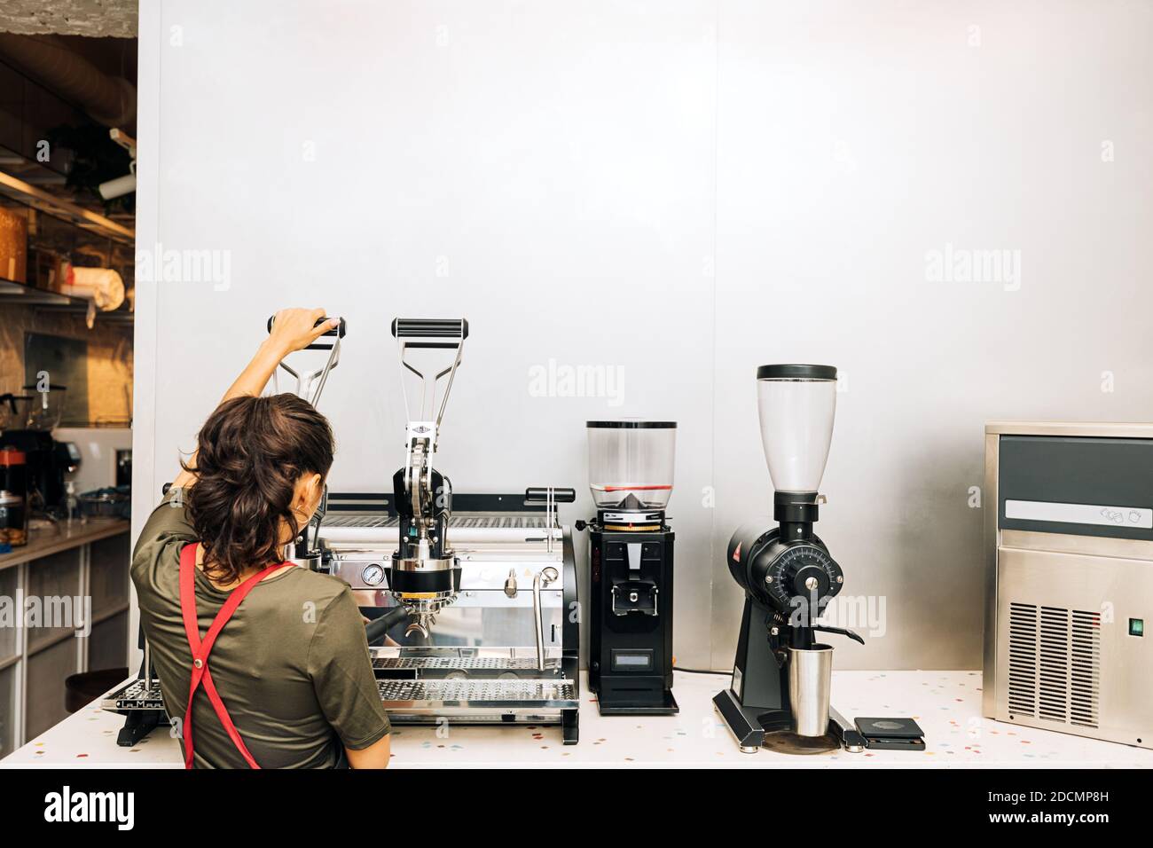 Vue arrière du barista utilisant la cafetière du café Banque D'Images