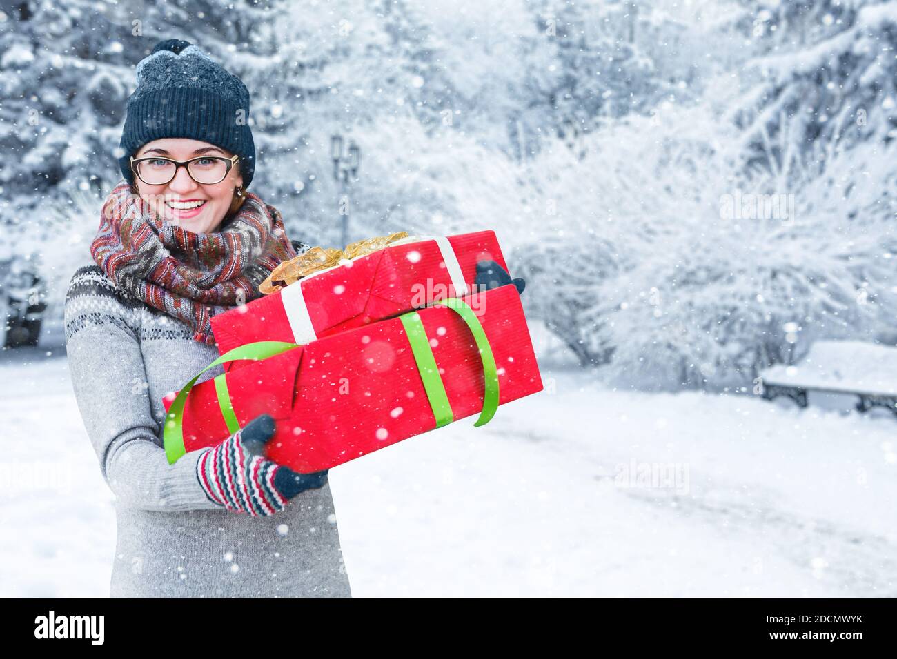 Femme avec cadeaux dans des boîtes rouges. Banque D'Images