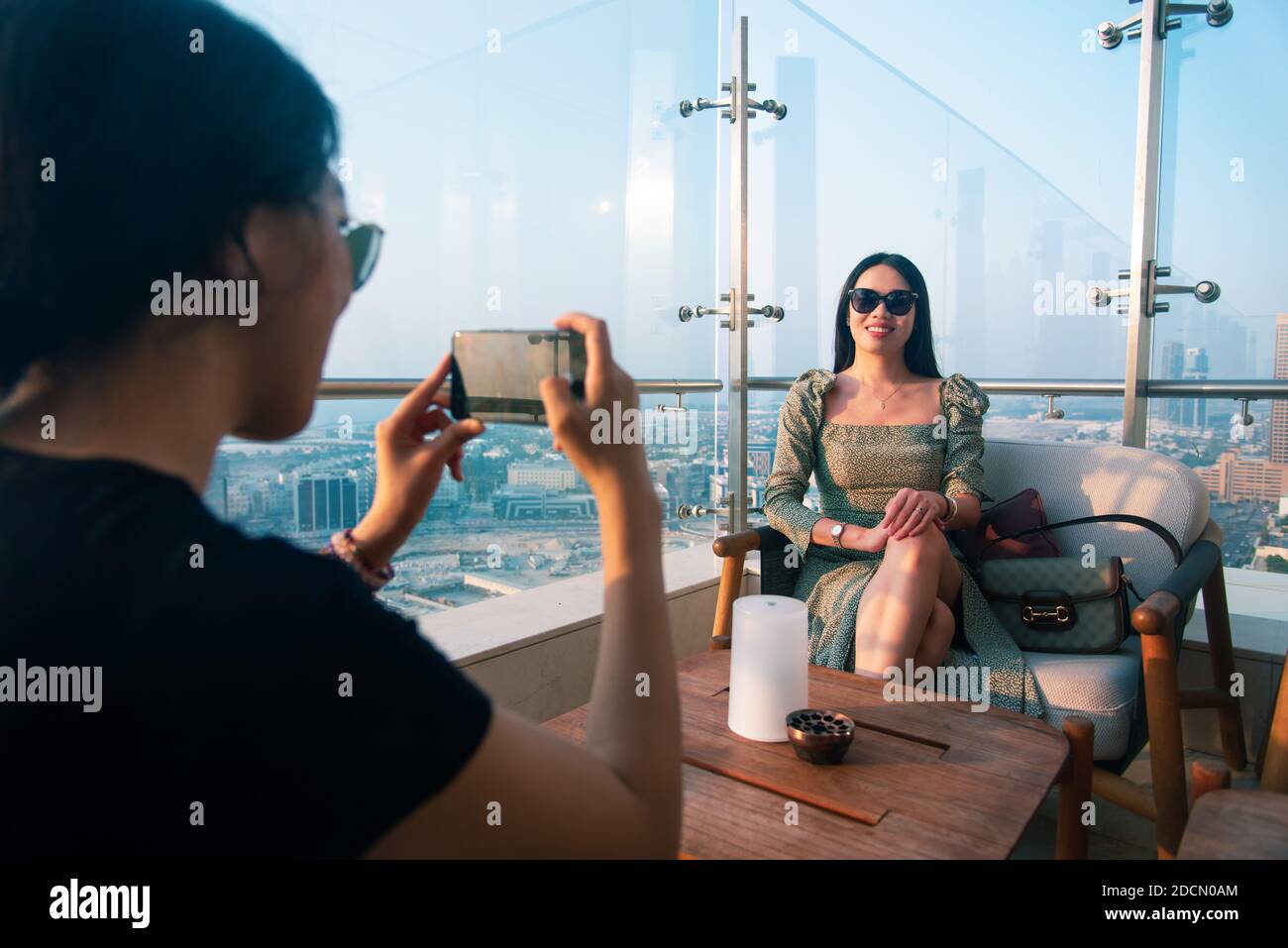 Femme fille amis prenant des photos dans le café-bar de haute vue au coucher du soleil. L'amitié féminine et le plaisir du temps abstrait Banque D'Images