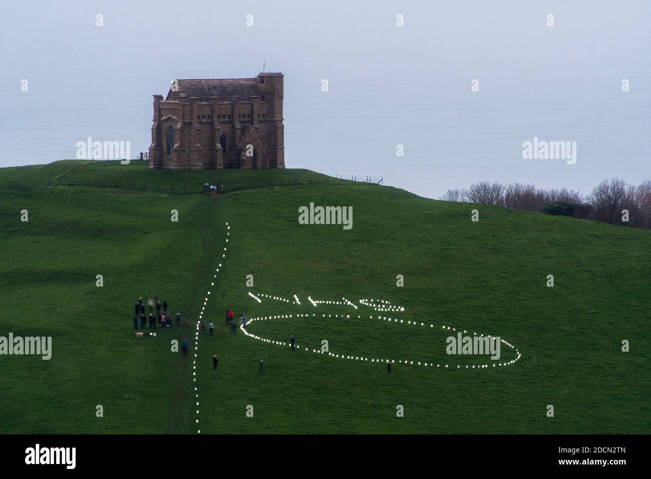 Abbotsbury, Dorset, Royaume-Uni. 22 novembre 2020. Météo au Royaume-Uni : l’événement caritatif annuel bougies sur la colline à la chapelle St Catheine’s Chapel à Abbotsbury, dans le Dorset, se poursuit au crépuscule avec le NHS écrit dans des lumières au-dessus du cercle de lumière sur le chemin menant à la chapelle pendant le confinement de Covid-19, lors d’une soirée de drizzly. Crédit photo : Graham Hunt/Alamy Live News Banque D'Images