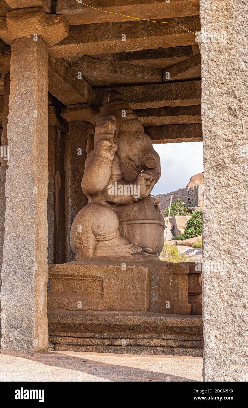Krishnapura, Karnataka, Inde - 4 novembre 2013 : vue latérale de Sasivekaly Ganesha ou de Mustard Seed résidant dans son sanctuaire de pierre brune. Feuillage vert Banque D'Images