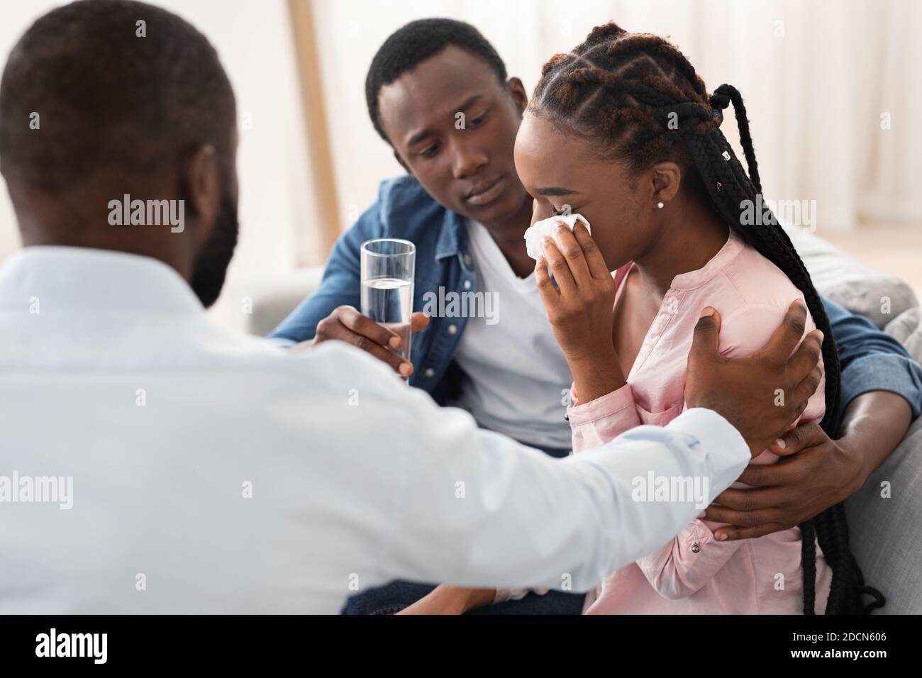 Le mari noir attentionné et le psychologue réconfortant la femme qui pleure pendant la famille Thérapie Banque D'Images