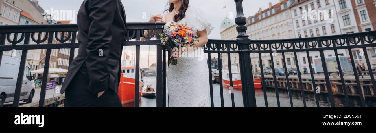 Couple de mariés à l'endroit emblématique de Nyhavn à Copenhague. Concept d'agence de mariage. Banque D'Images Couple de mariés à l'endroit emblématique de Nyhavn à Copenhague. Concept d'agence de mariage. Banque D'Images