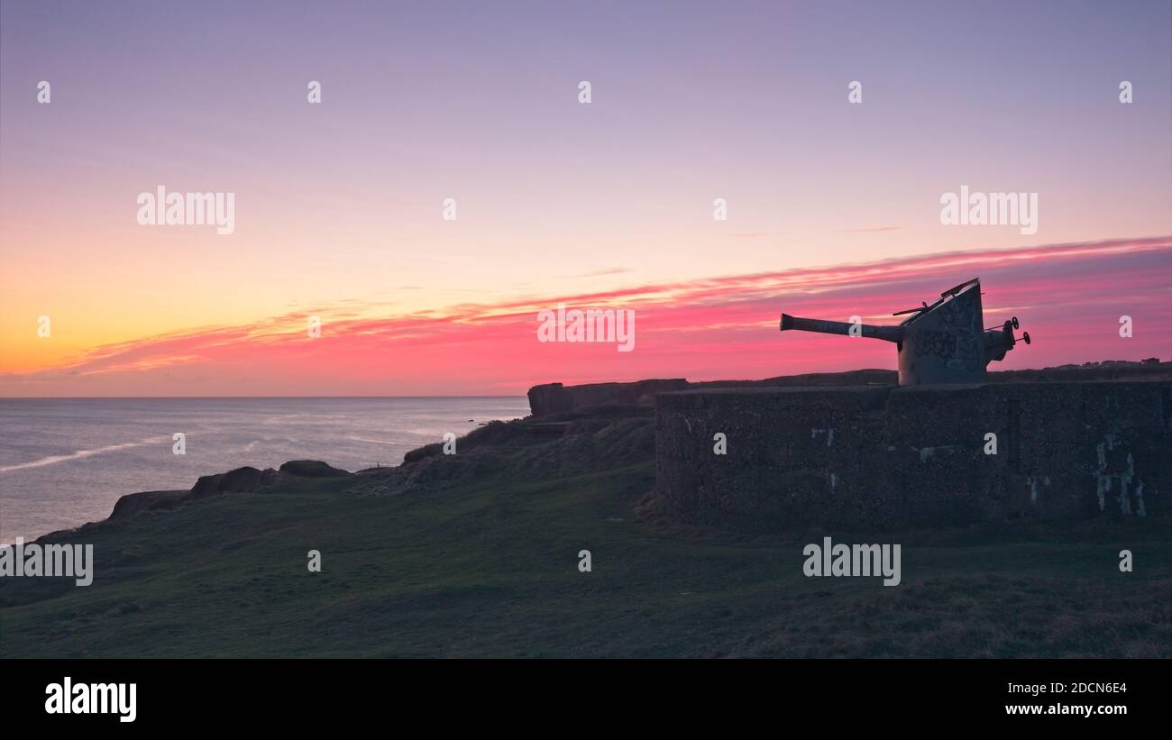 L'artillerie côtière de la Seconde Guerre mondiale surplombe la mer du Nord à Trow point, South Shields, Tyne et Wear capturés presque en silhouette au lever du soleil. Banque D'Images