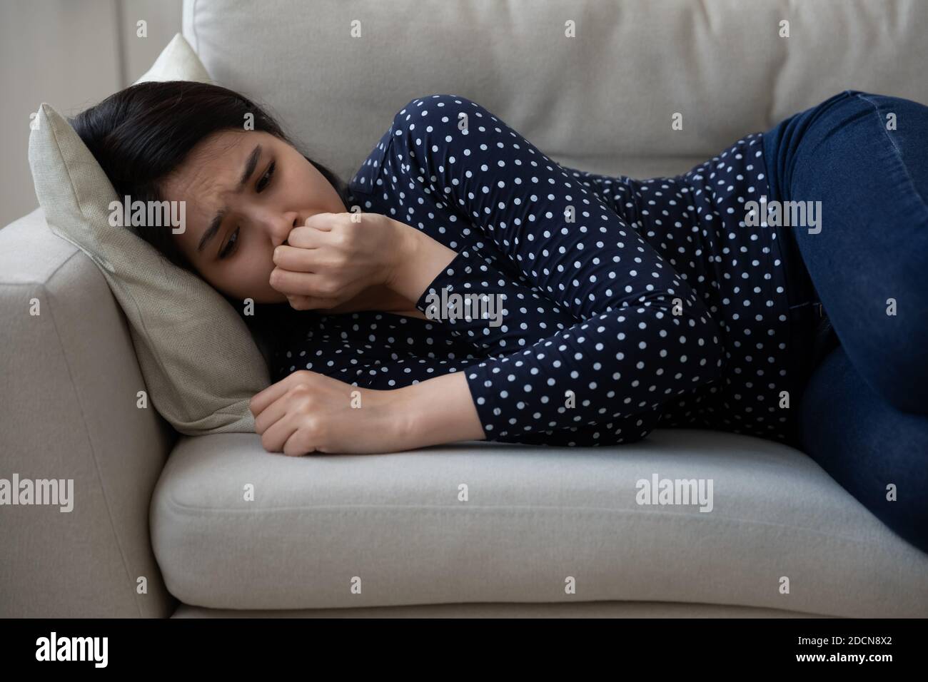 Malheureux déprimé asiatique jeune femme couché sur le canapé seul, pleurant Banque D'Images