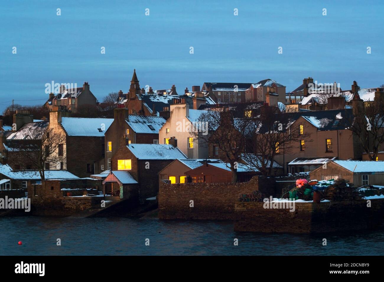 Lever du soleil d'hiver avec de la neige sur les toits de pierre traditionnelle construite Maisons dans la ville écossaise sur les îles Orcades Banque D'Images