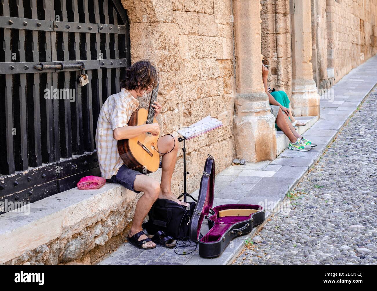 Un musicien de rue joue la guitare classique dans la rue Ippoton (rue des  Chevaliers), l'un des points forts de la ville médiévale de Rhodes Photo  Stock - Alamy