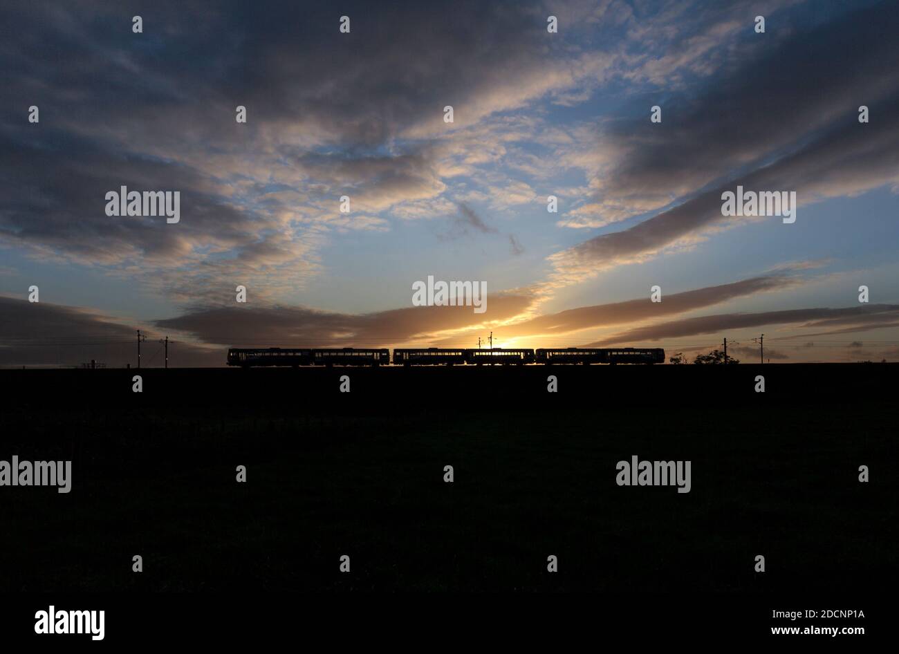 3 trains de banlieue de classe 142 du Northern Rail fonctionnant à vide sur la ligne principale de la côte ouest au coucher du soleil, retournant au service après-vente Banque D'Images