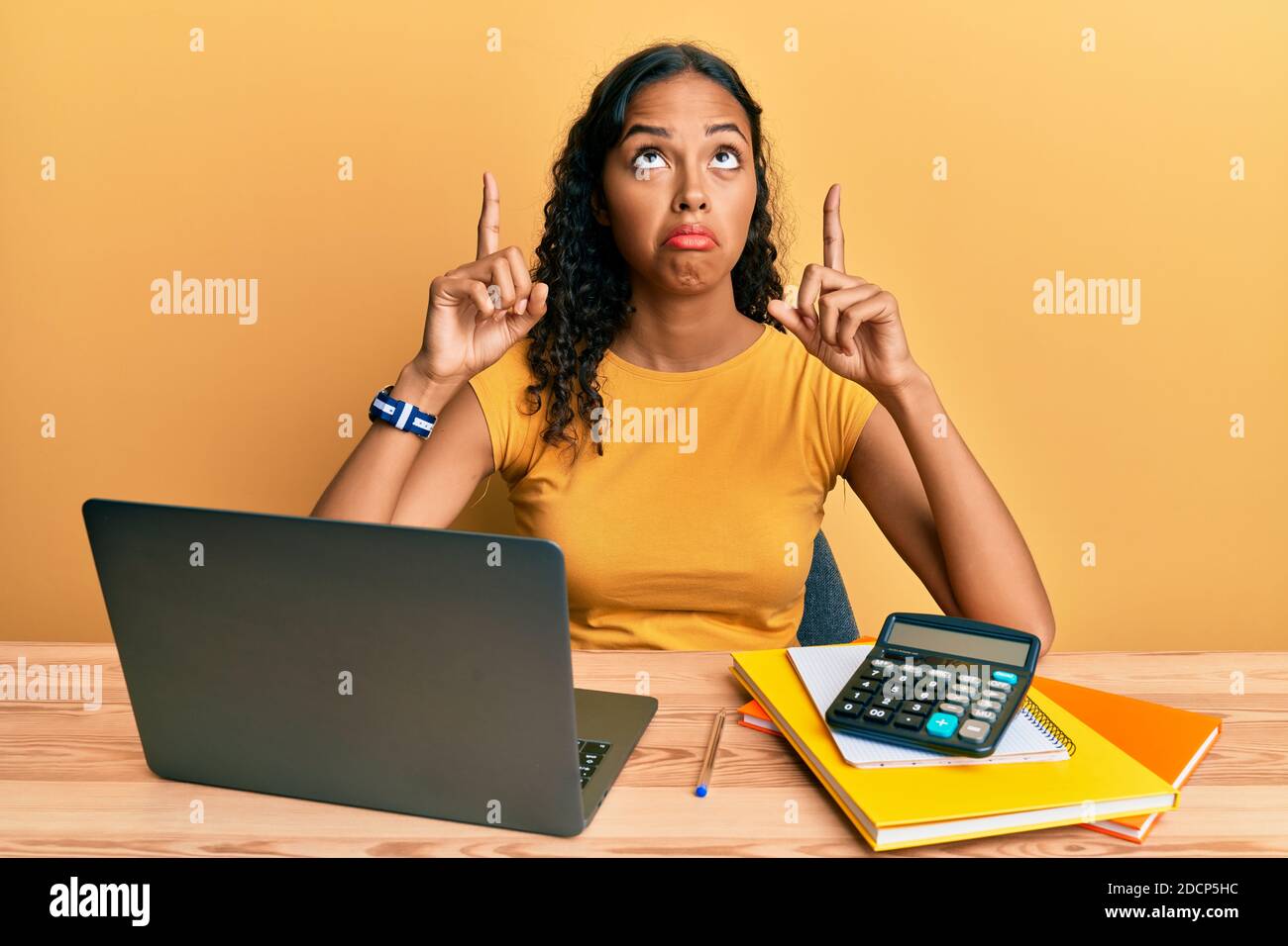 Jeune fille afro-américaine travaillant au bureau avec un ordinateur ...