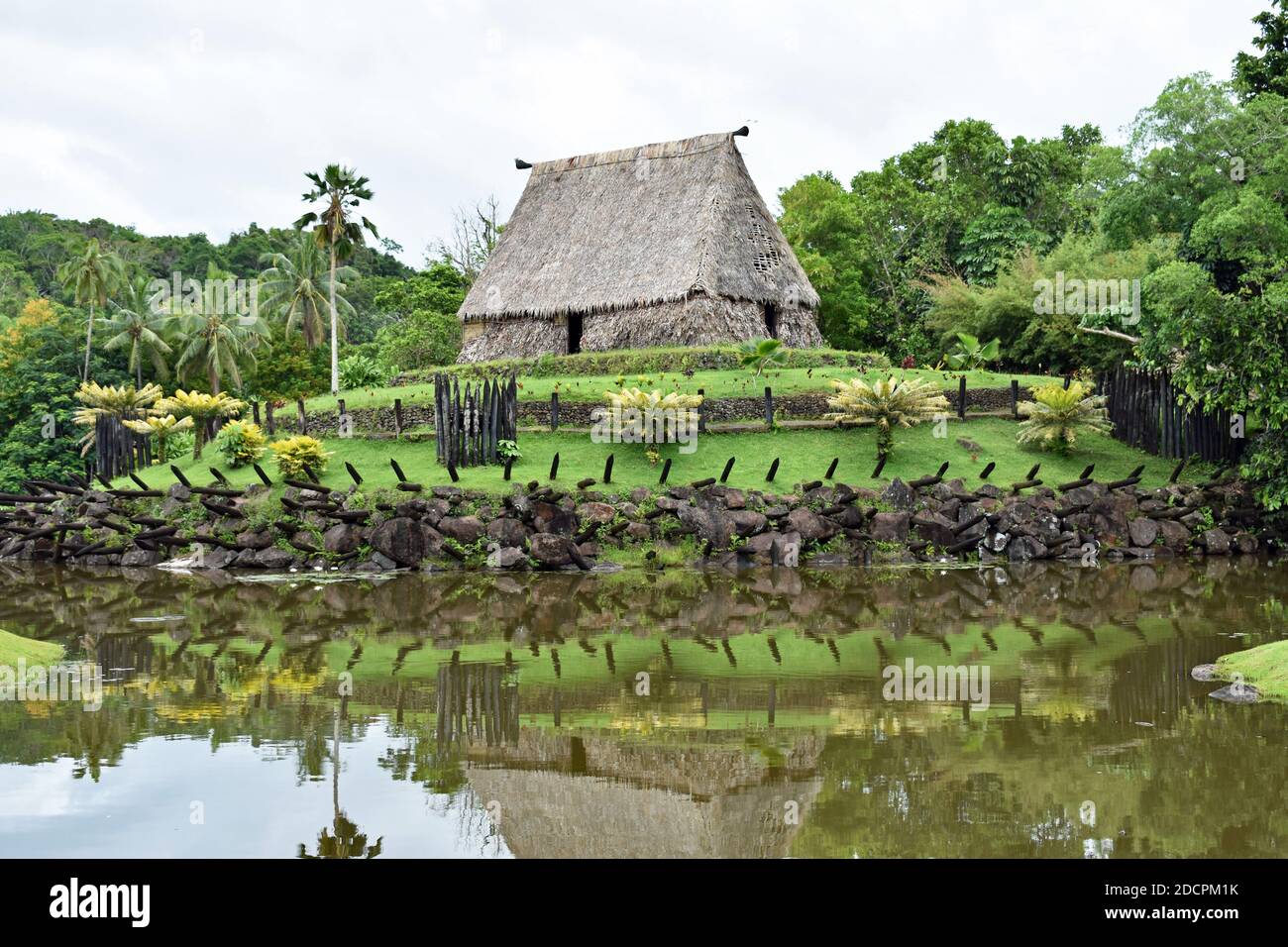 Le Bure Kalau (maison d'esprit) au Pacific Harbour Arts Village près de Suva aux Fidji. La maison est et la verdure se reflète dans un petit lac. Banque D'Images