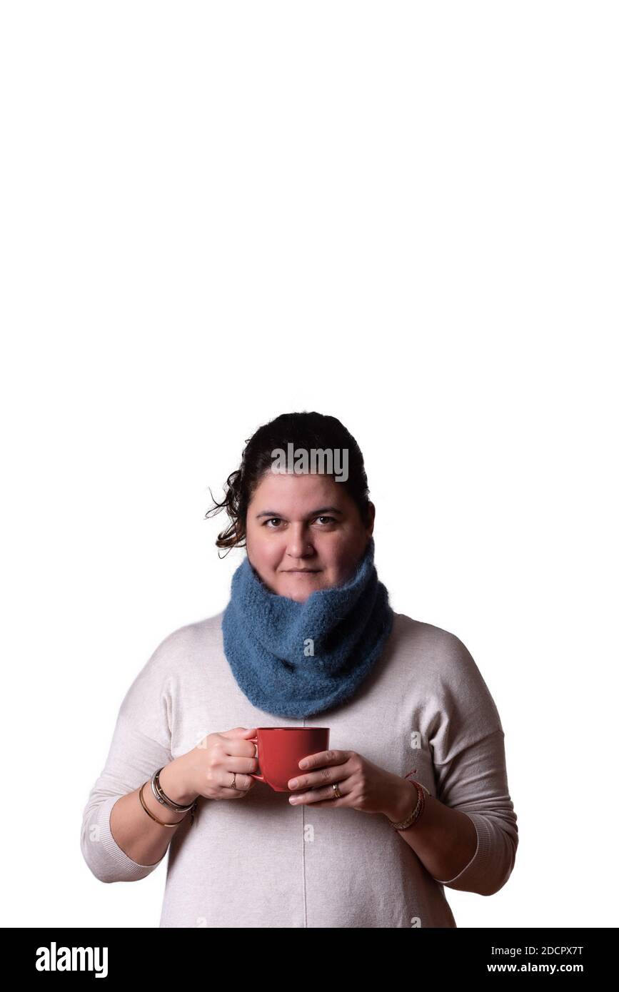 Portrait vertical d'une femme qui a une tasse de thé rouge dans ses mains sur fond blanc. Concept d'hiver. Copier l'espace Banque D'Images